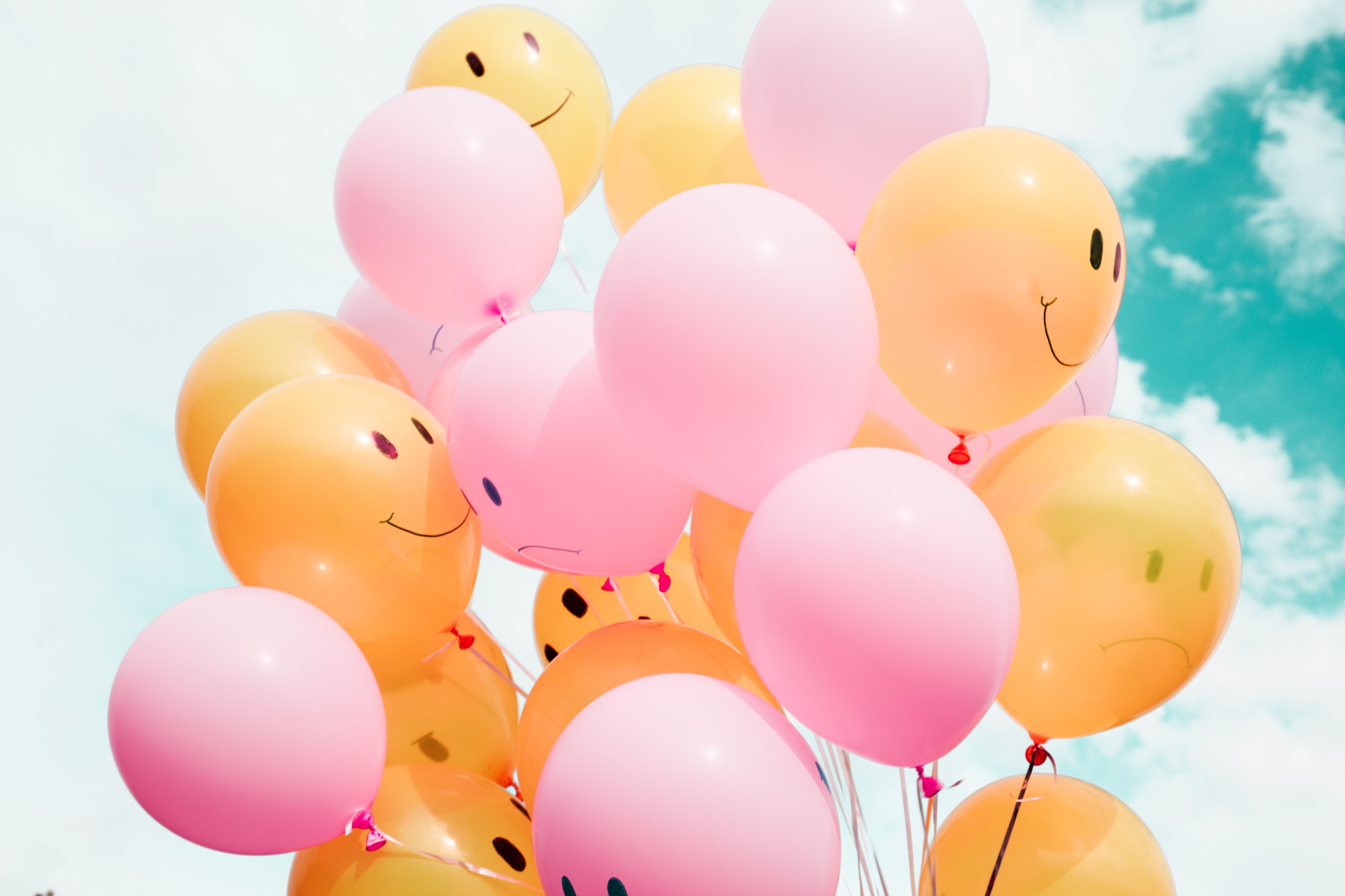 A bunch of balloons with smiley faces on them.