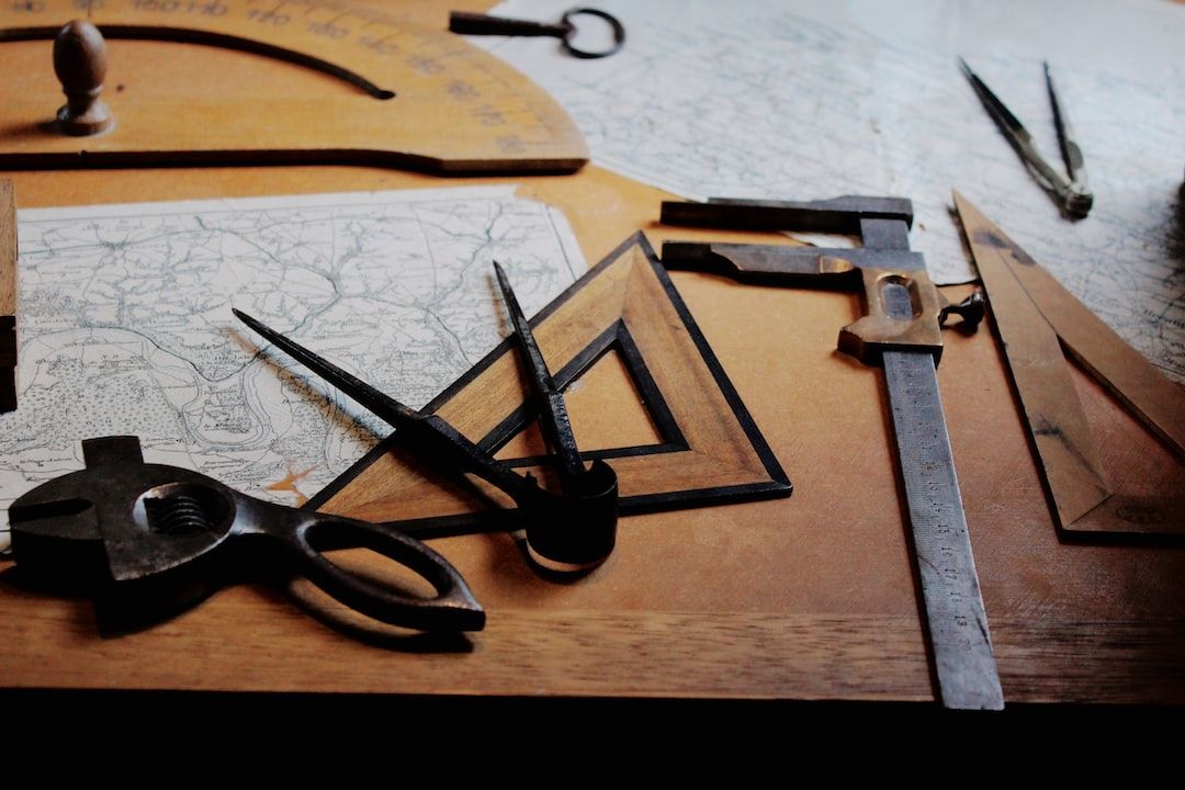 Multiple crafting tools lay on a wooden desk and symbolize the essential data science tools mentioned in this blog article